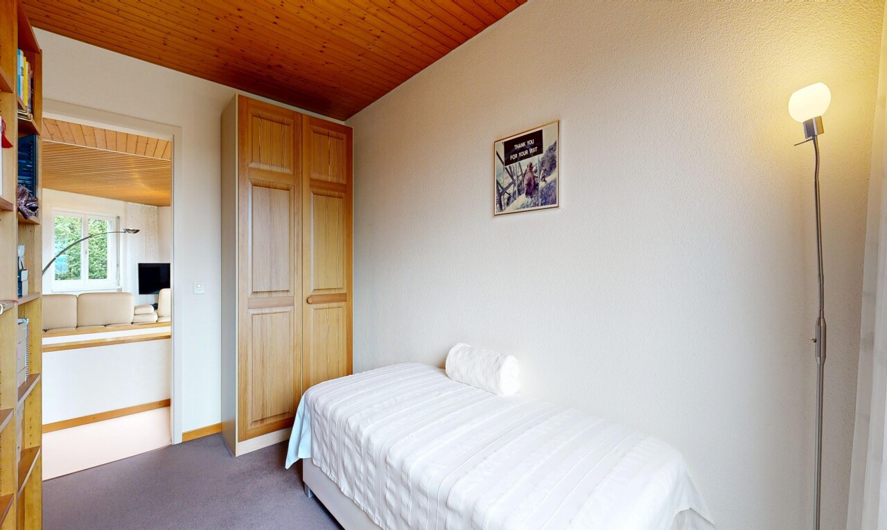 room with wooden ceiling and dark colored carpet