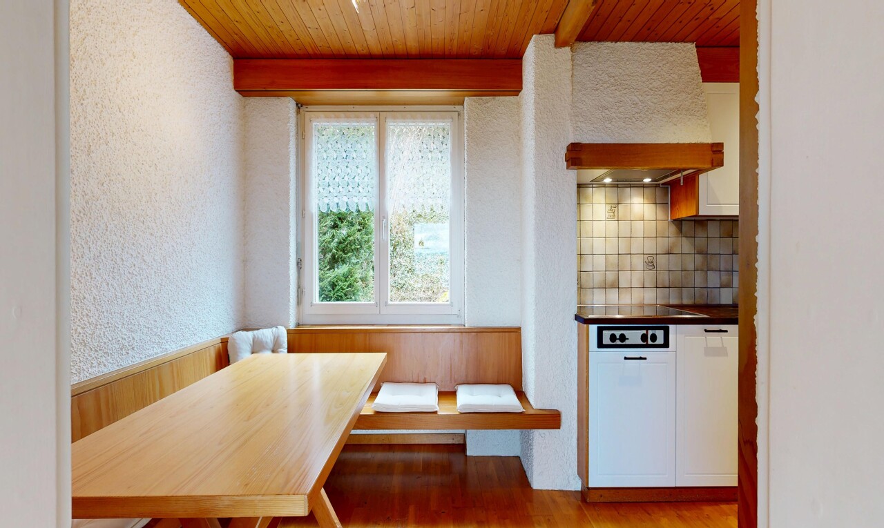 dining room with breakfast area, a wood ceiling with exposed beams, a textured wall, light wood-style floors, and a wainscoted wall