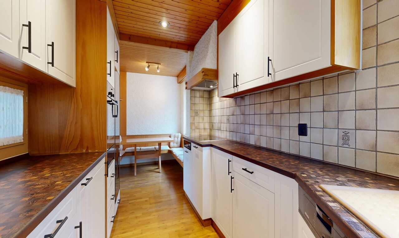 kitchen with dark countertops, white cabinetry, light wood-style flooring, tasteful backsplash, and wood ceiling