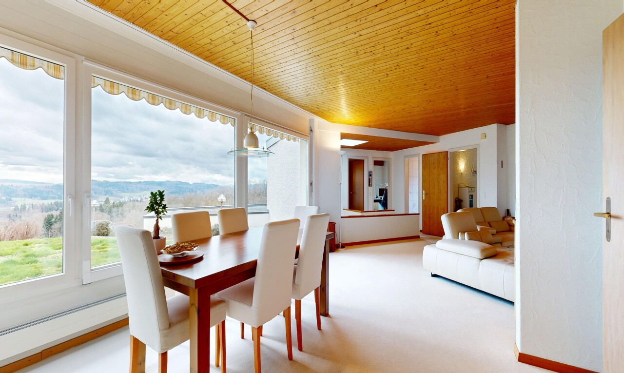 living / dining area with light colored carpet and wood ceiling