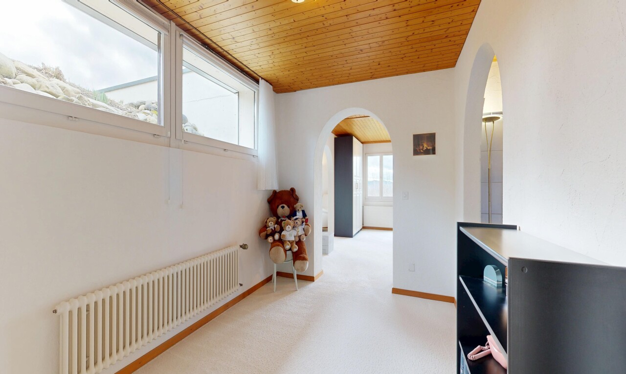 hallway with radiator, wood ceiling, light colored carpet, and arched walkways