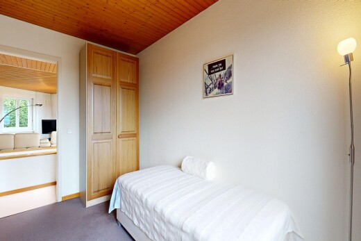 room with wooden ceiling and dark colored carpet