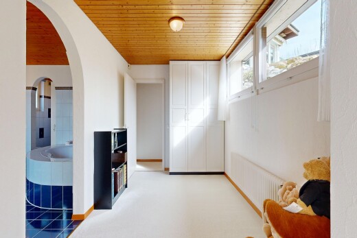 hall featuring arched walkways, wooden ceiling, and light colored carpet