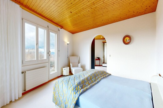 carpeted room featuring arched walkways, radiator heating unit, wooden ceiling, and access to outside