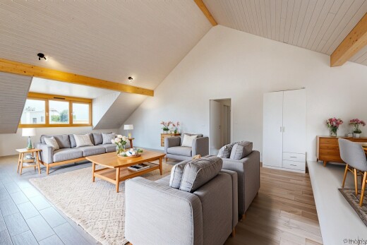 wohnzimmer mit balkendecke, beamed ceiling, dachschräge, vaulted ceiling, und holzfußboden