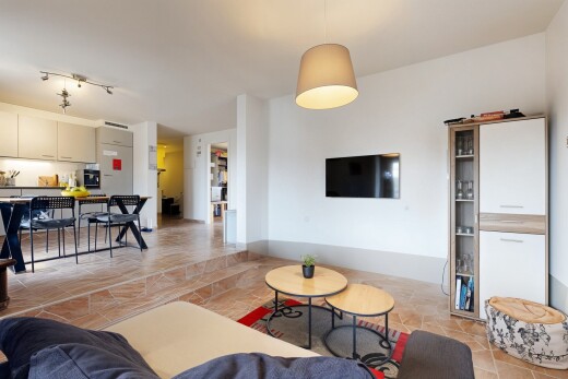 salon / salle à manger avec sol en finition pierre, stone finish floor, télévision, inside property, et cloison sèche