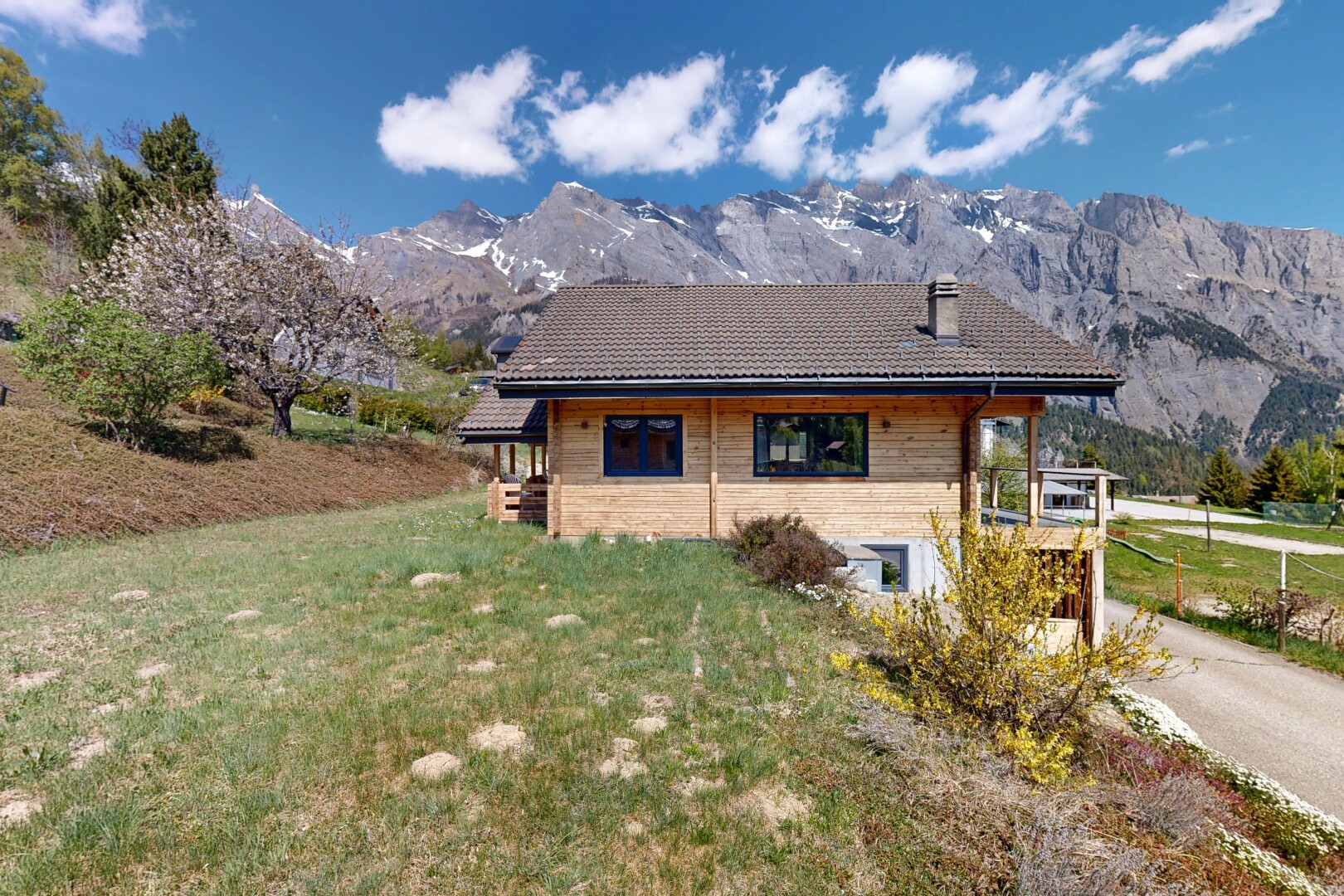 outdoor house featuring a lawn, a mountain view, and a tile roof