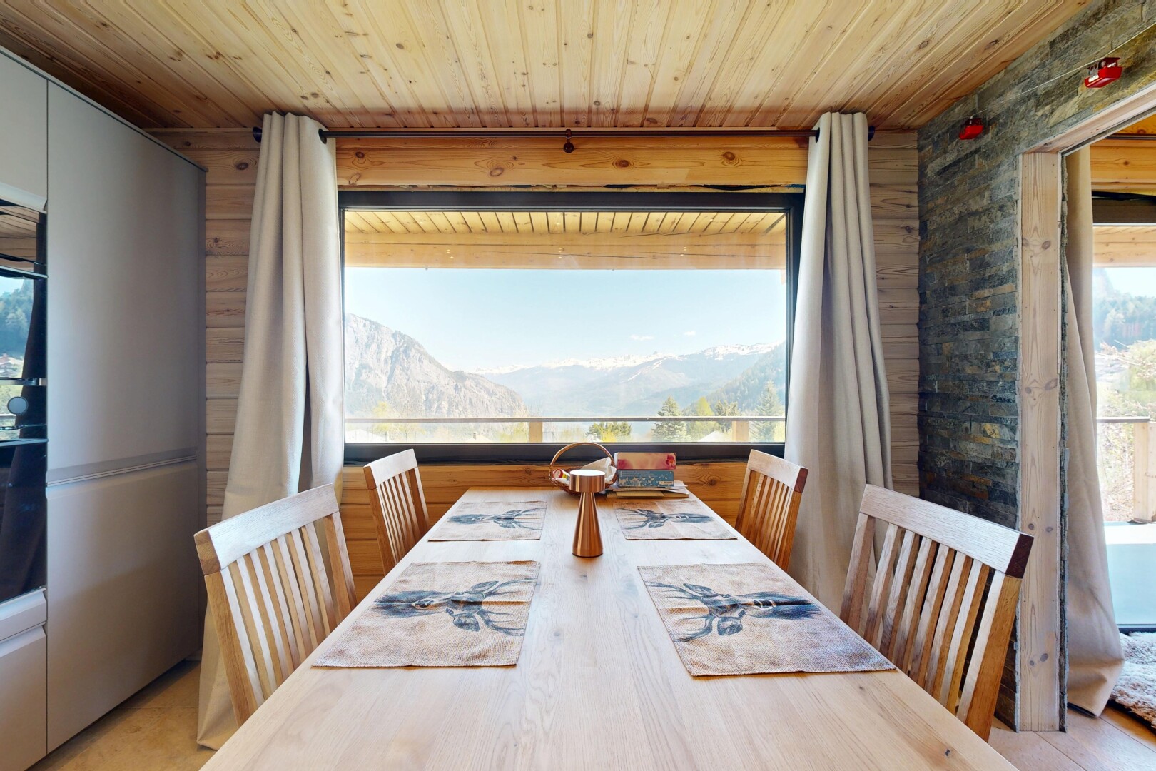 dining area with a mountain view, healthy amount of natural light, and wooden ceiling