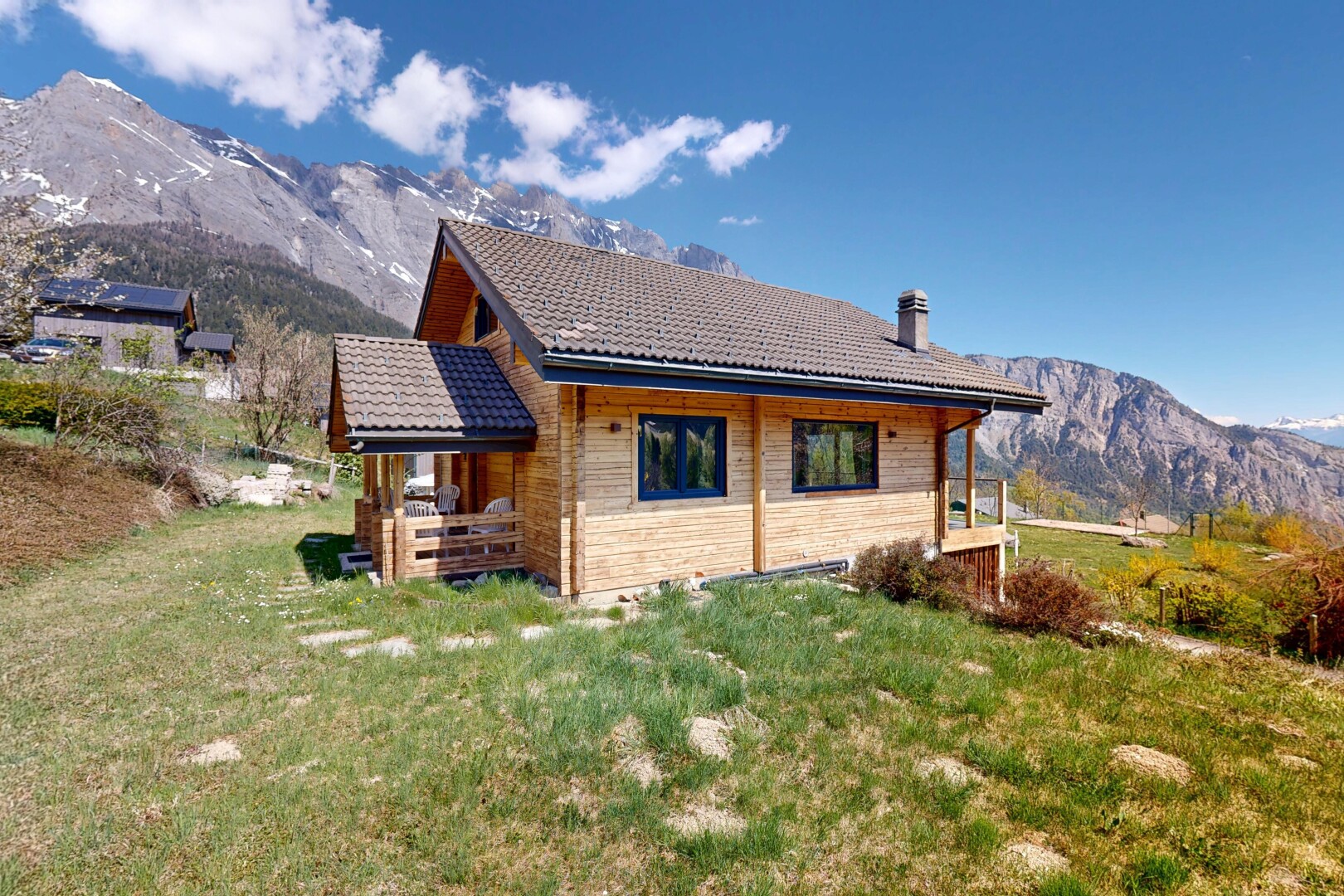 view of property with a mountain view, a lawn, a tiled roof, and a chimney