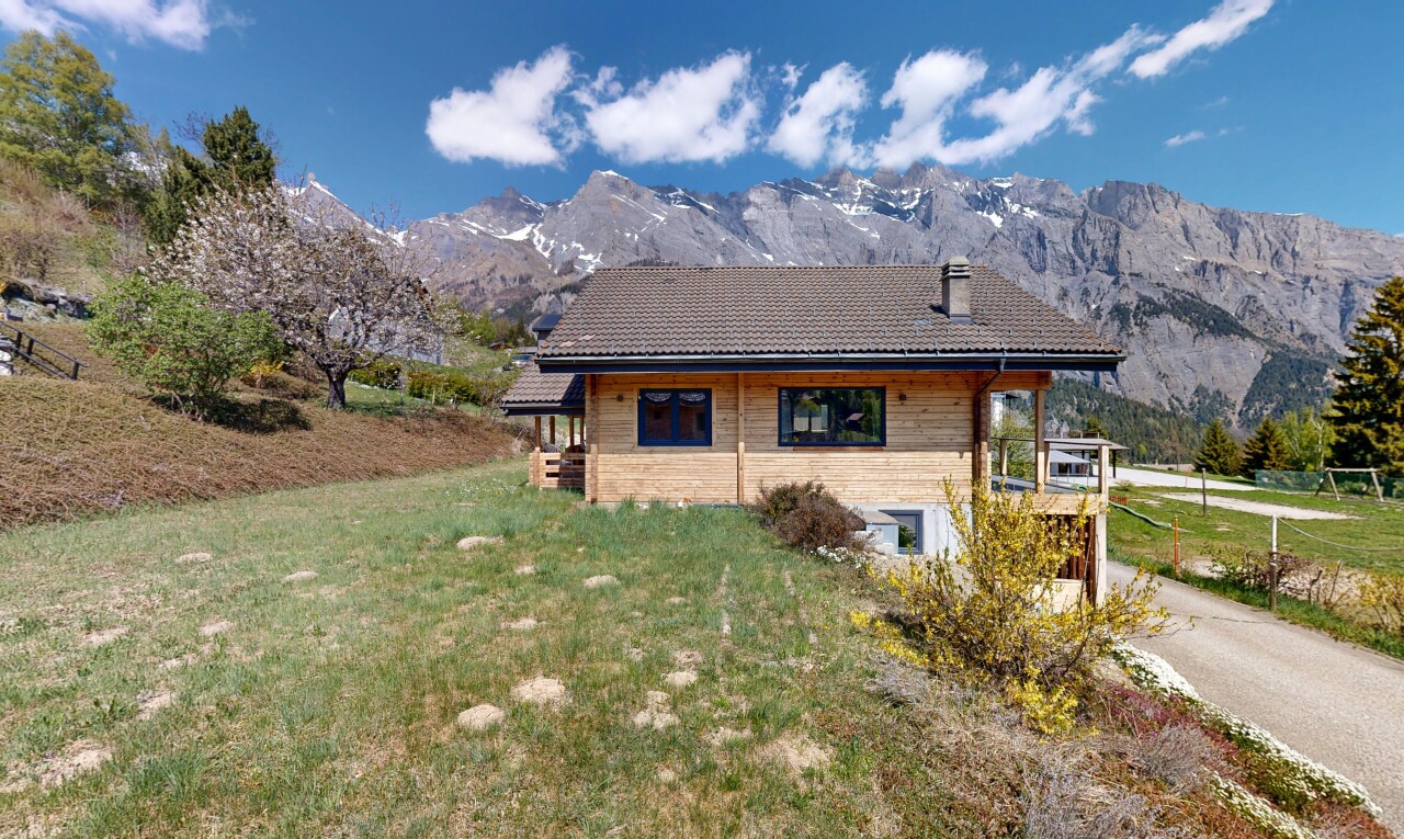 outdoor house featuring a lawn, a mountain view, and a tile roof