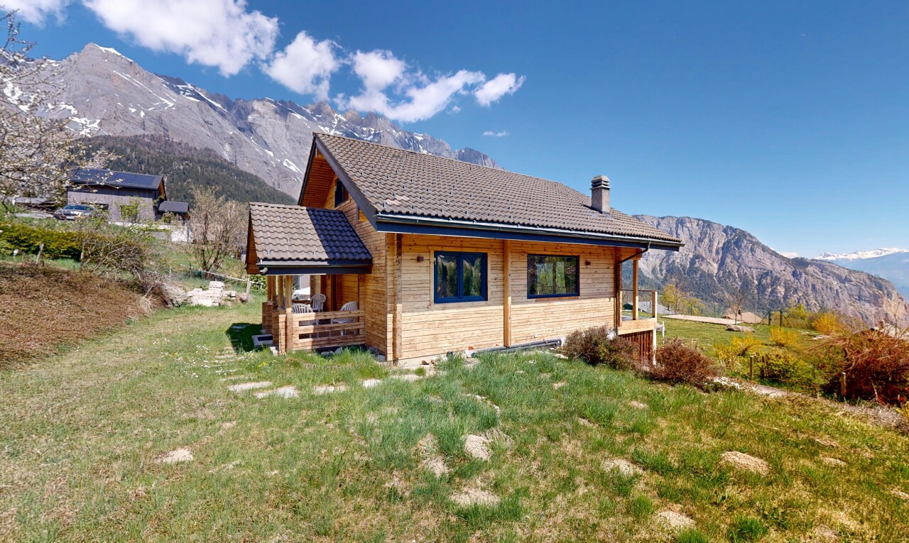 view of property with a mountain view, a lawn, a tiled roof, and a chimney