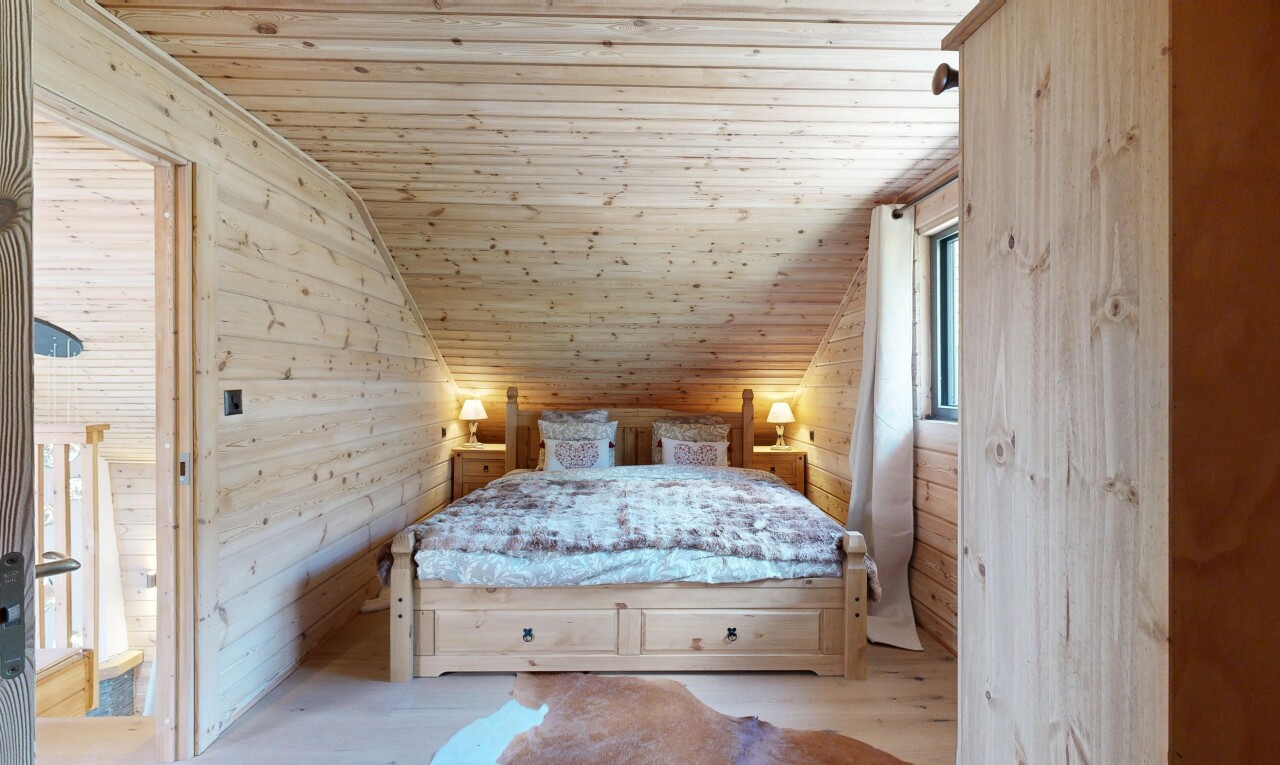 room featuring wooden walls, a vaulted wooden ceiling, and wood finished floors