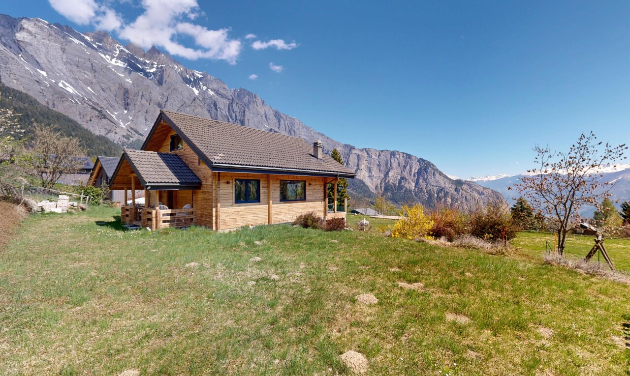 outdoor house featuring a mountain view and a yard