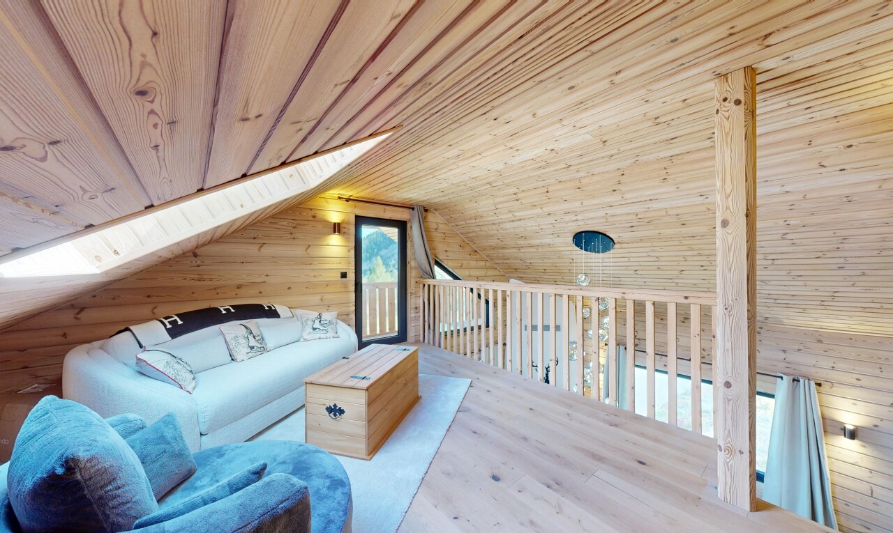 living area with wooden walls, a vaulted wood ceiling, and wood finished floors