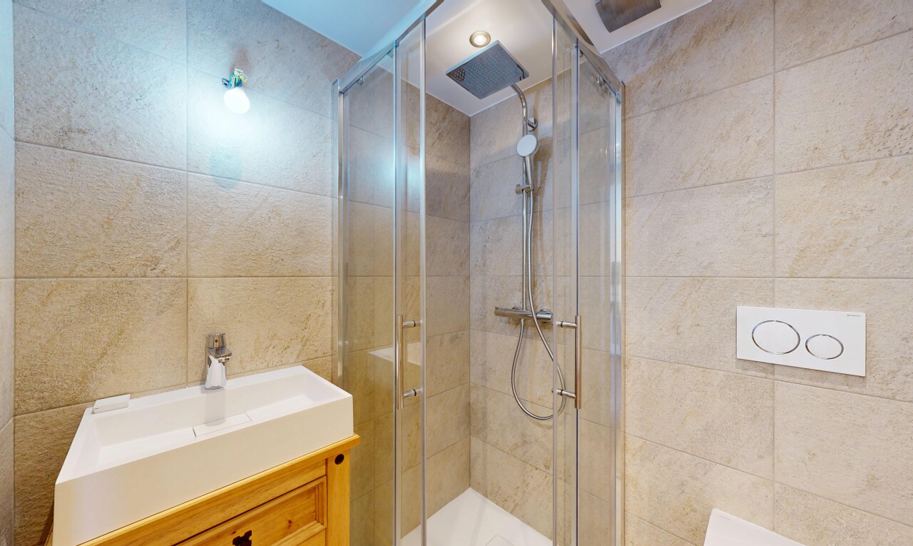 bathroom with vanity, tile walls, and a shower stall