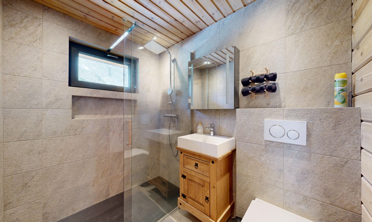 full bath with tile walls, vanity, and a walk in shower