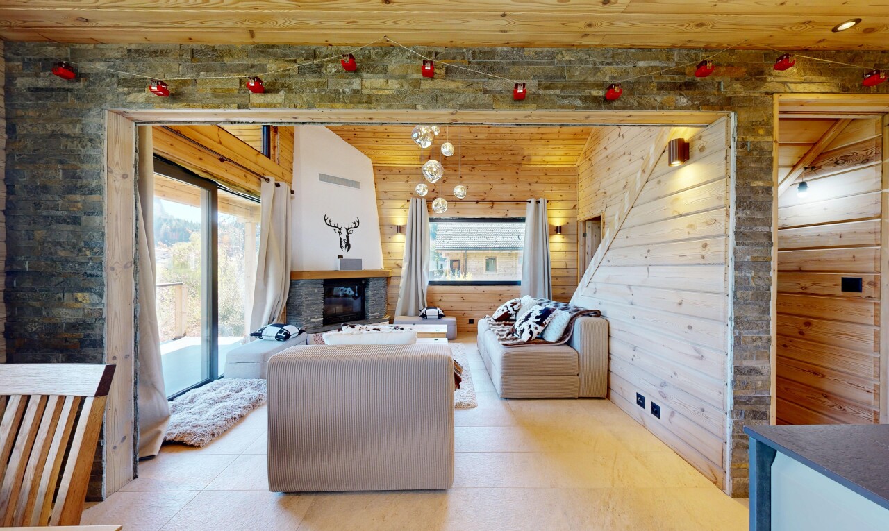 living area featuring a vaulted wood ceiling, a fireplace, and wooden walls