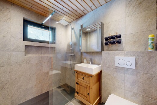 full bath with tile walls, vanity, and a walk in shower