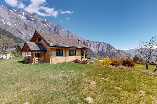 outdoor house featuring a mountain view and a yard