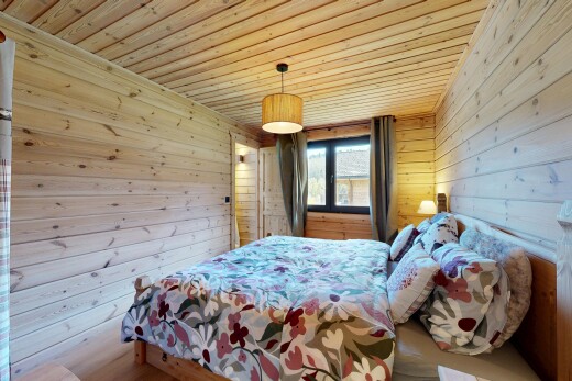 chambre avec wood wall, mur en bois, wood ceiling, plafond en bois, et natural light