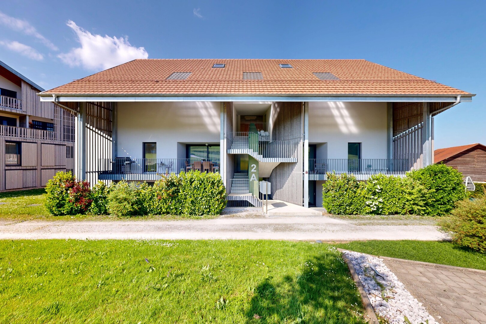 façade avec day time, toit en tuiles, porche, pelouse, et bardage en stuc