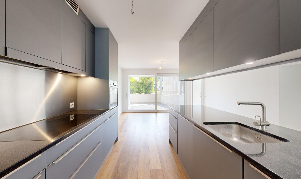 cuisine avec dark countertops, gray cabinets, armoires grises, inside property, et wood finish floor
