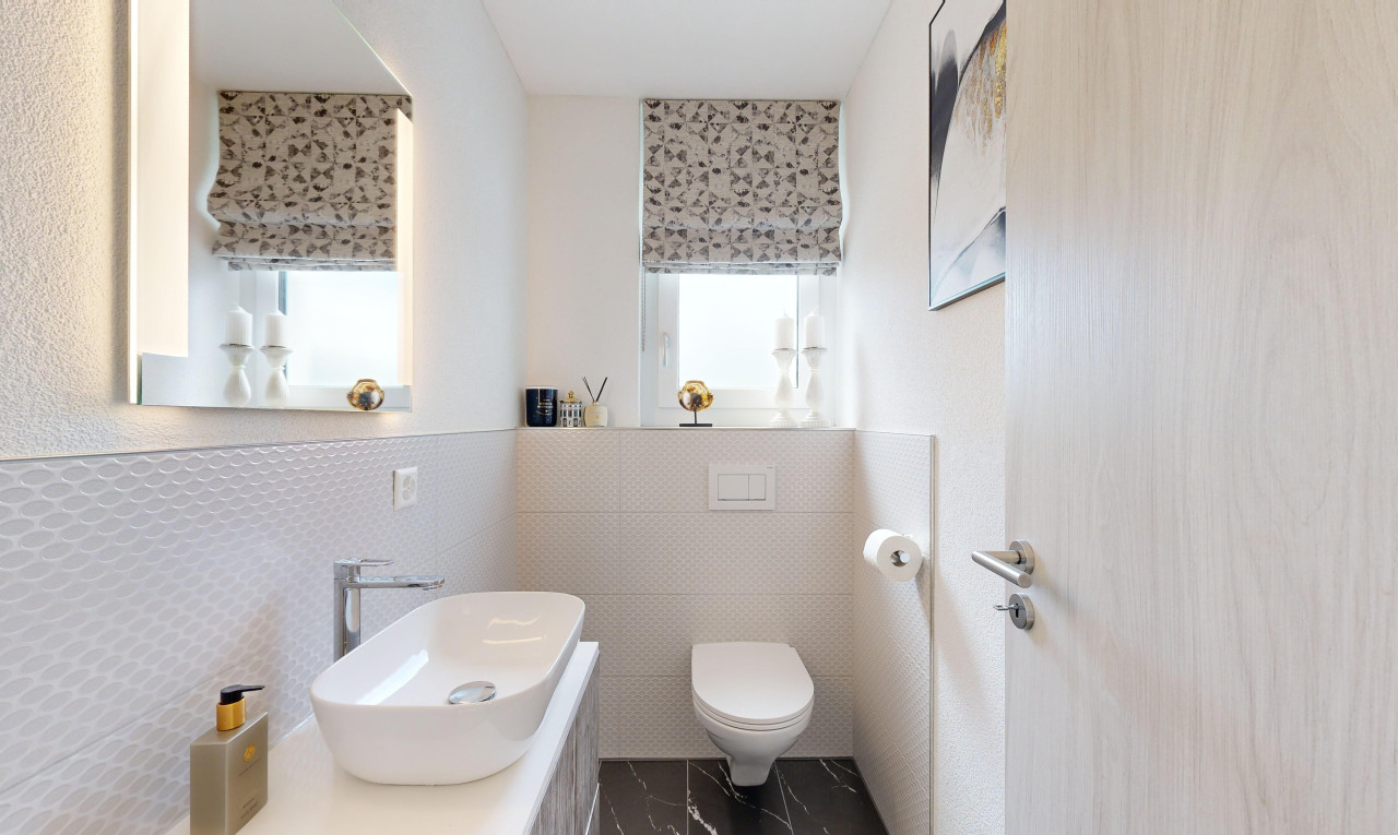 bad mit spiegel, fliesenwand, waschbecken, toilette, und natürliches licht