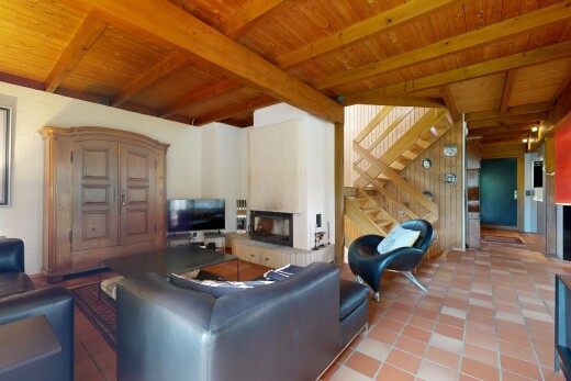 living room with a fireplace with raised hearth, light tile patterned floors, a wood ceiling with exposed beams, stairway, and wood walls