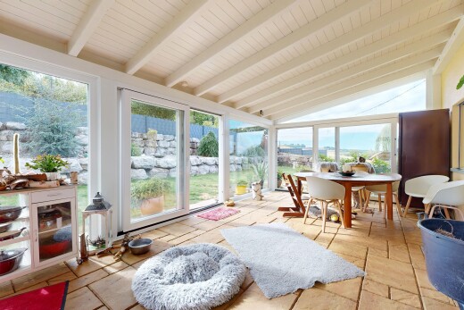 dining area with vaulted ceiling with beams and stone tile floors