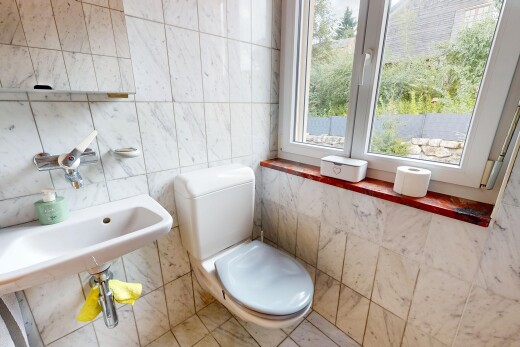 half bathroom featuring toilet and tile walls
