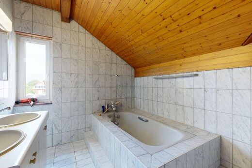full bathroom with tile walls, a vaulted wood ceiling, a garden tub, and double vanity