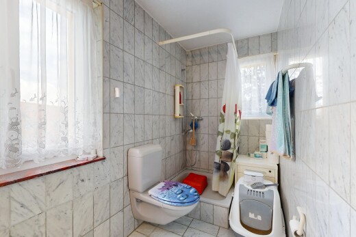bathroom with a tile shower, tile walls, and light tile patterned floors