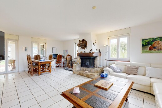 living / dining area featuring light tile patterned floors and a stone fireplace