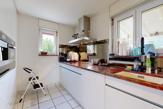 kitchen featuring extractor fan, light tile patterned floors, white cabinets, and dark stone countertops