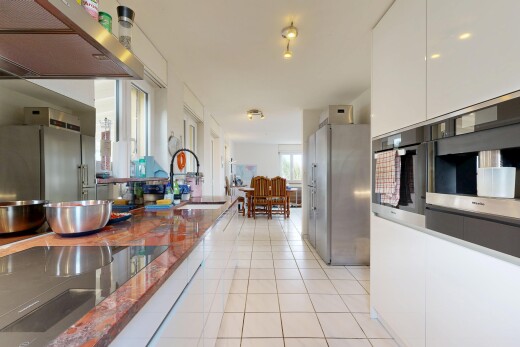 kitchen with ventilation hood, white cabinetry, stainless steel oven, light tile patterned floors, and dark stone counters