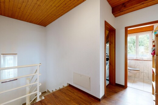 corridor featuring wooden ceiling, an upstairs landing, and wood finished floors