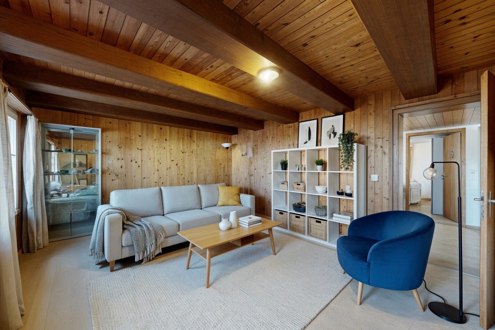 salon avec mur en bois, wood wall, plafond à poutres, beamed ceiling, et plafond en bois