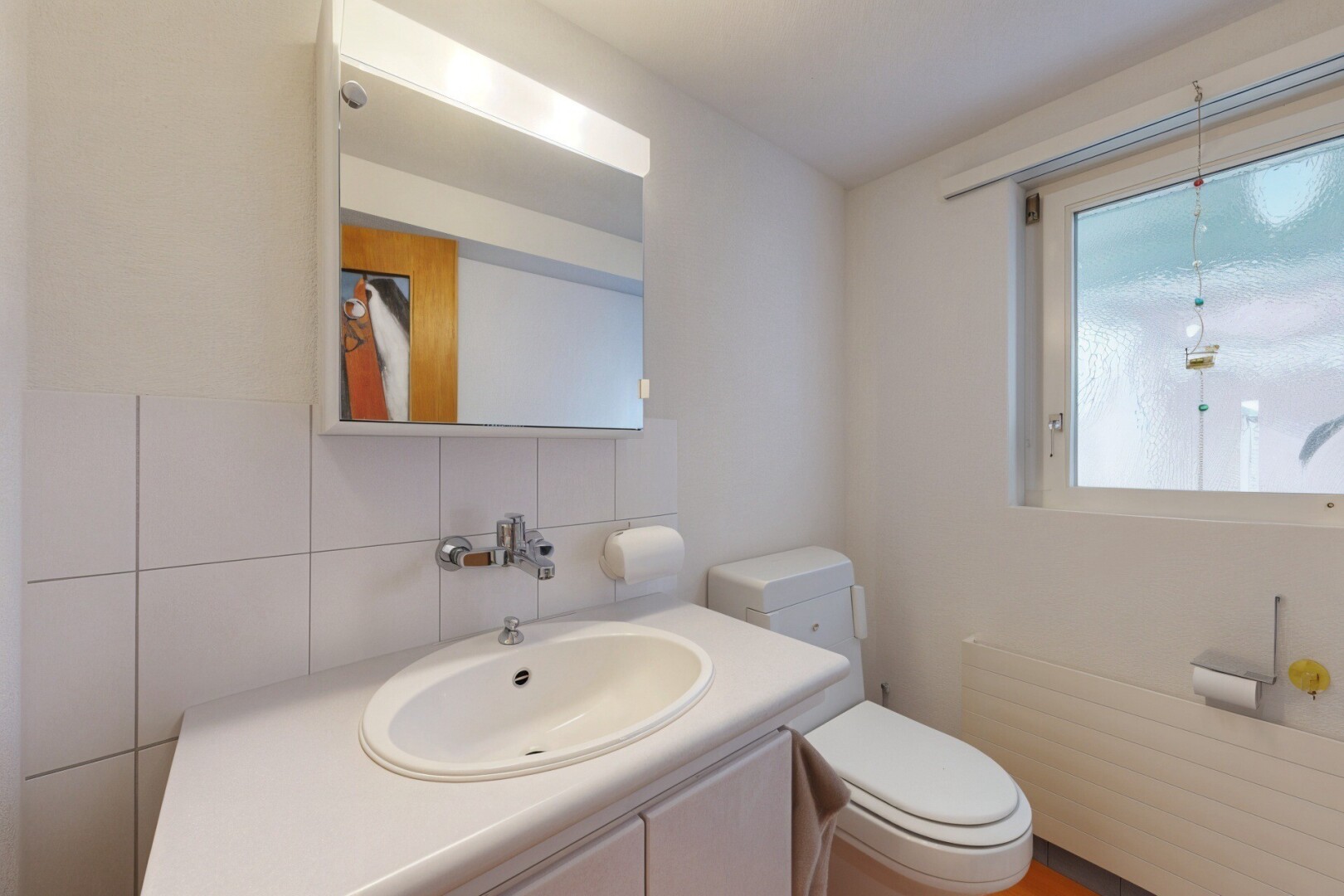 salle de bains avec miroir, évier, inside property, lavabo (ou coiffeuse selon le contexte), et toilette