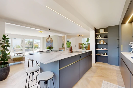 küche mit light countertops, schränke mit flachen paneelen, flat panel cabinets, light floor, und holzfußboden