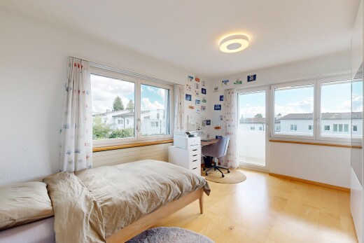 chambre avec espace bureau, cloison sèche, drywall, day time, et sol en finition bois