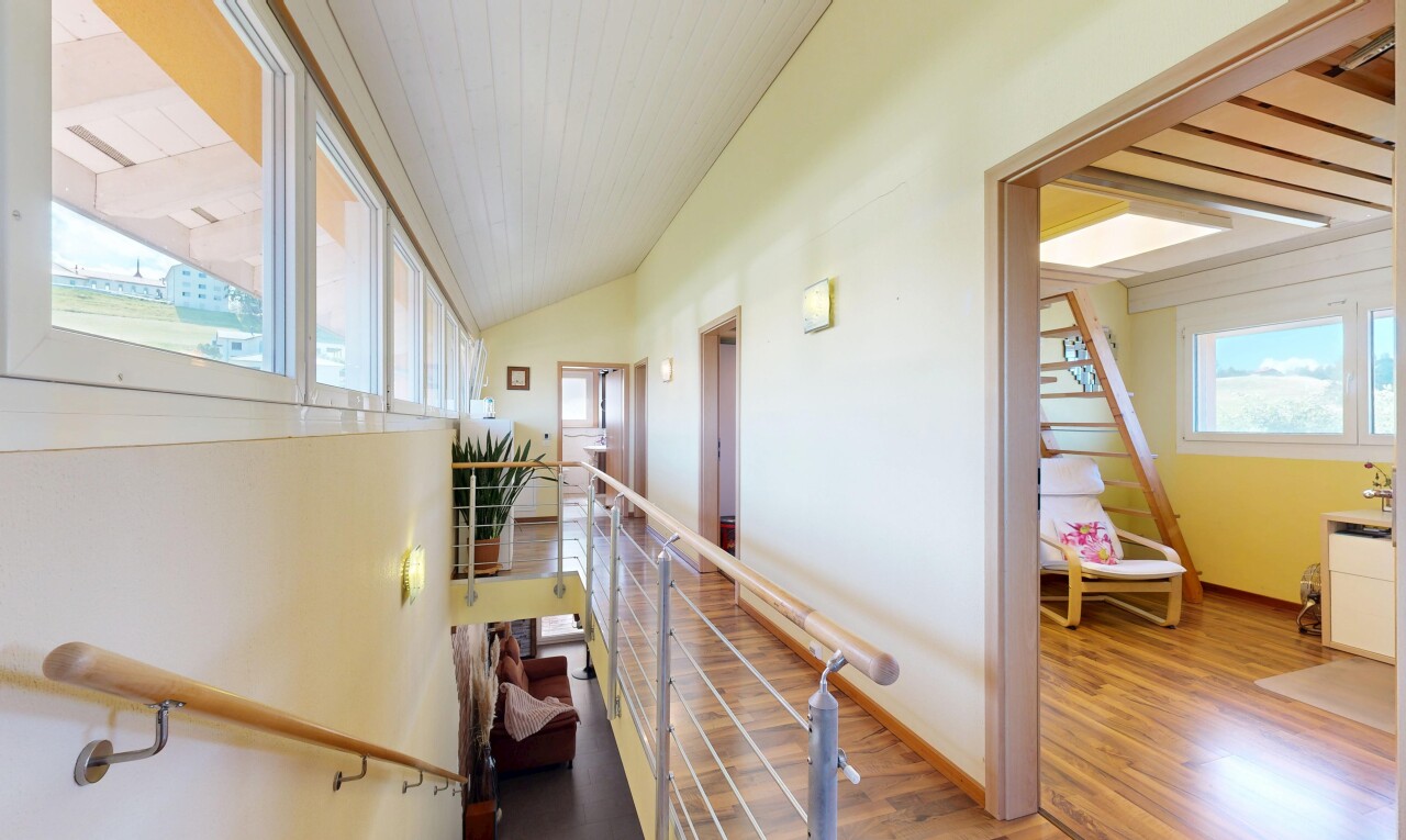 escaliers avec sol en finition bois, wood finish floor, cloison sèche, drywall, et inside property