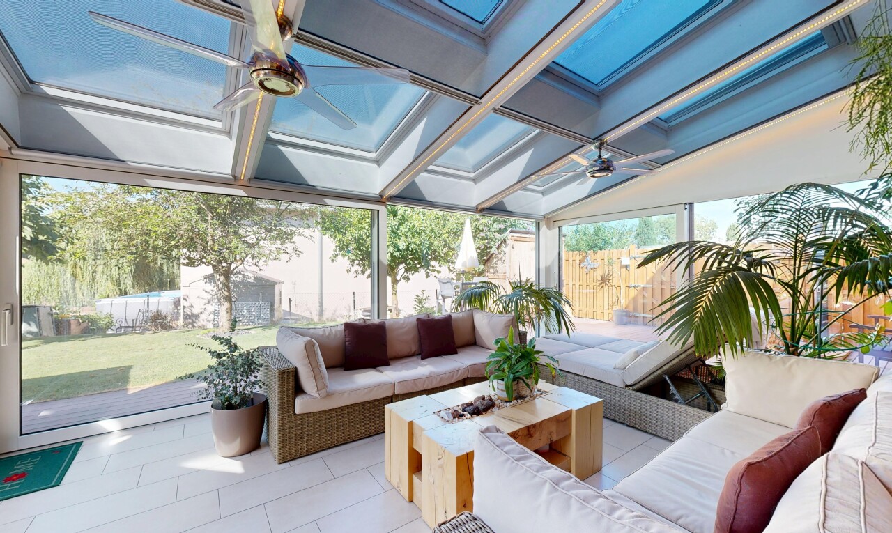 terrasse avec clôture, ventilateur de plafond, espace de vie extérieur, foyer extérieur, et day time