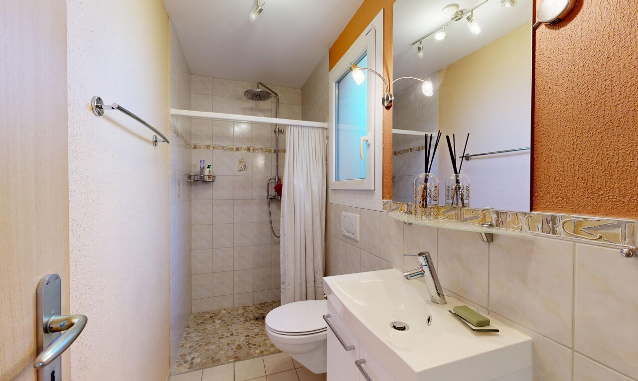 salle de bains avec miroir, douche, lavabo (ou coiffeuse selon le contexte), salle de bain complète, et inside property