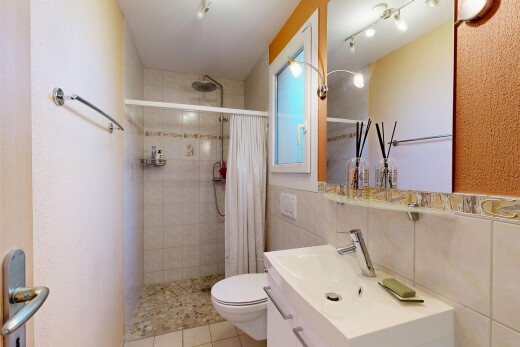 salle de bains avec miroir, douche, lavabo (ou coiffeuse selon le contexte), salle de bain complète, et inside property