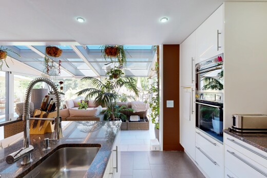 cuisine avec dark countertops, white cabinets, armoires blanches, évier, et stone countertops