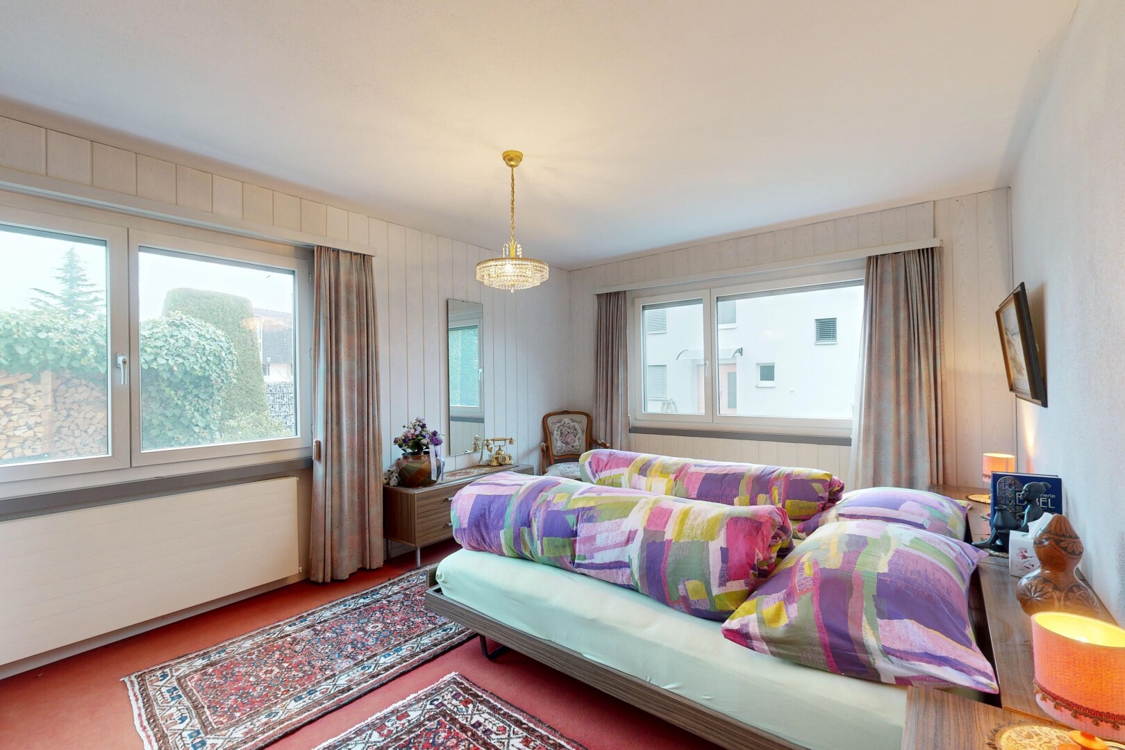 room featuring multiple windows, carpet flooring, and a chandelier