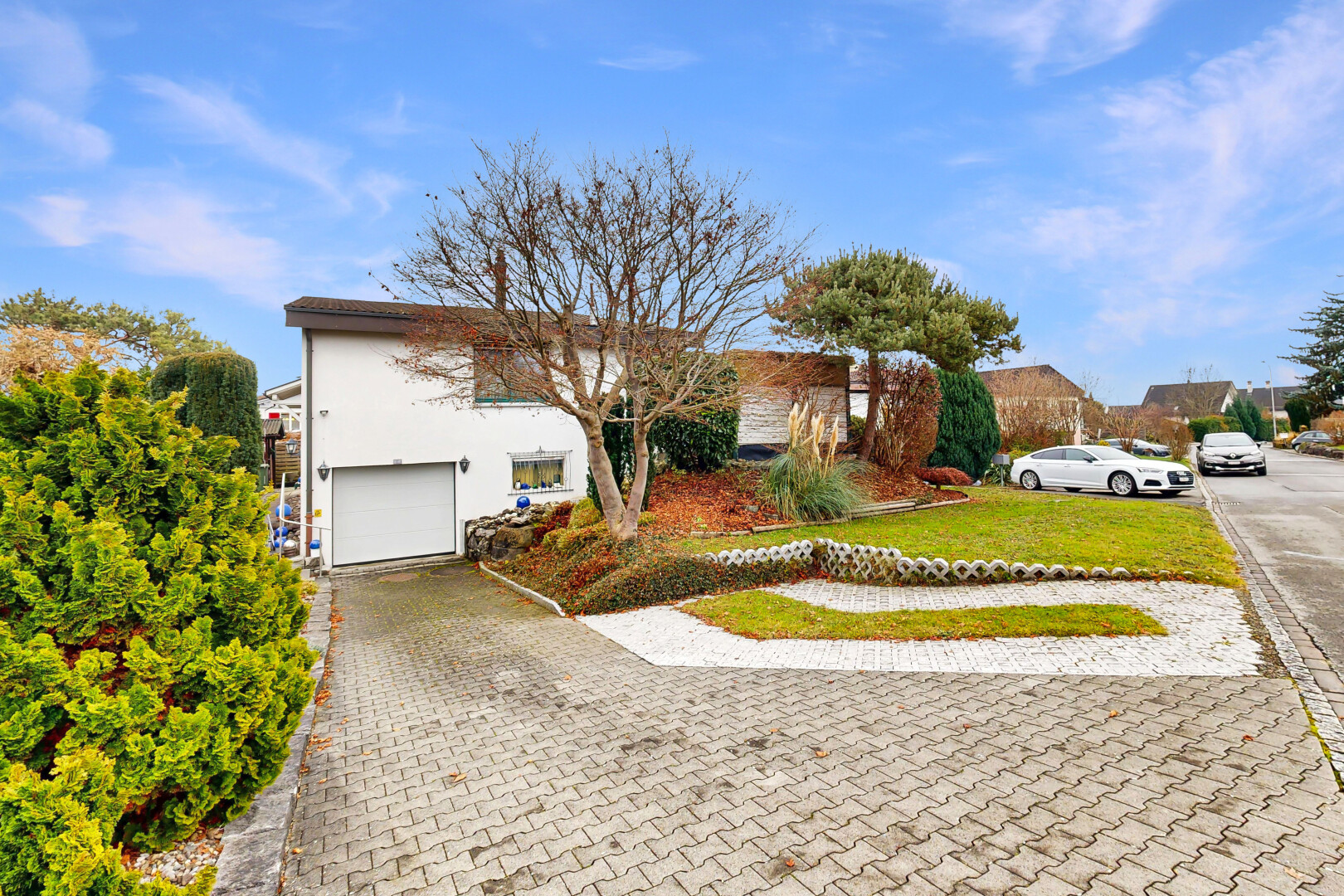 view of home with a lawn, an attached garage, driveway, and stucco siding
