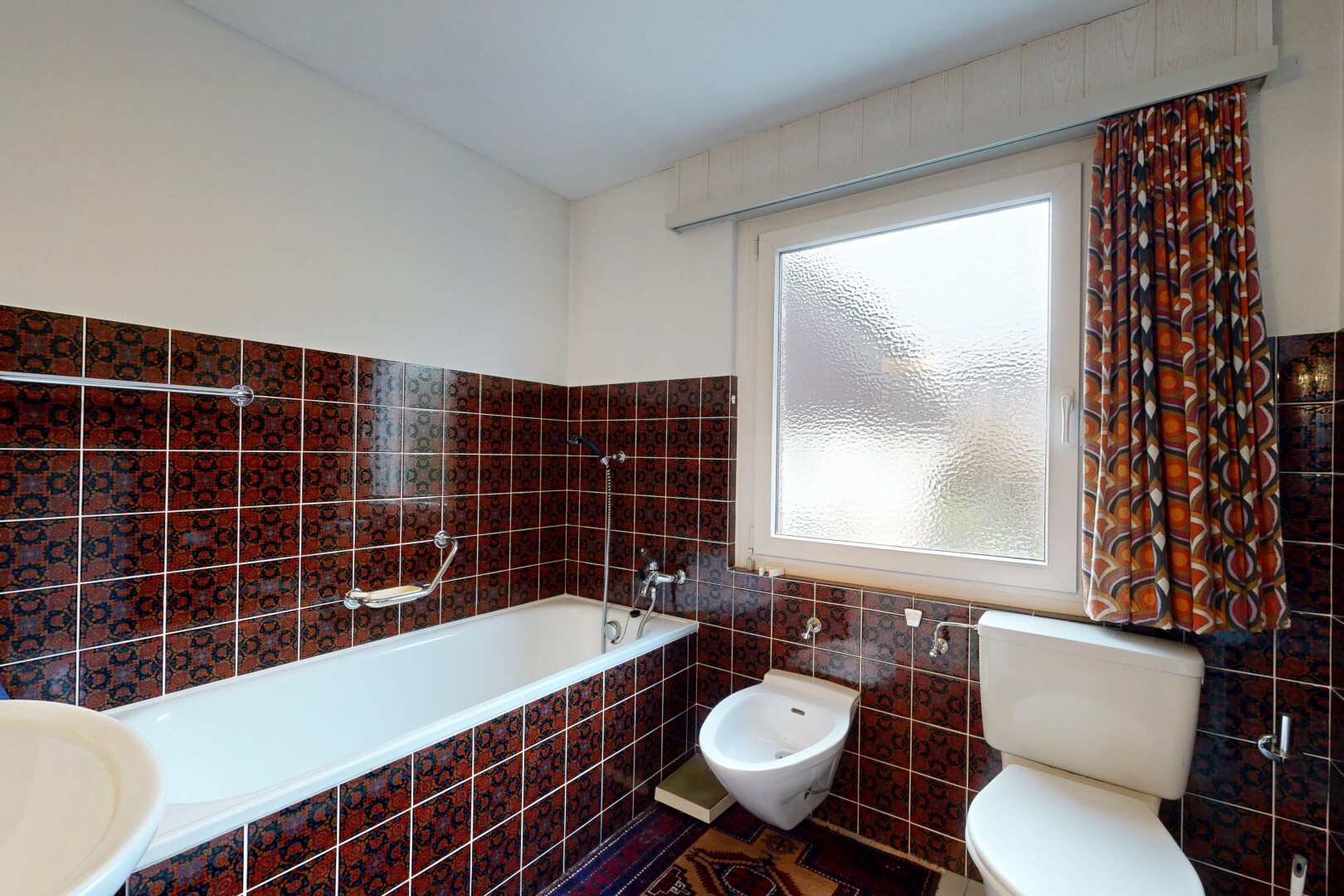 bathroom with tile walls, a garden tub, a bidet, and a wainscoted wall