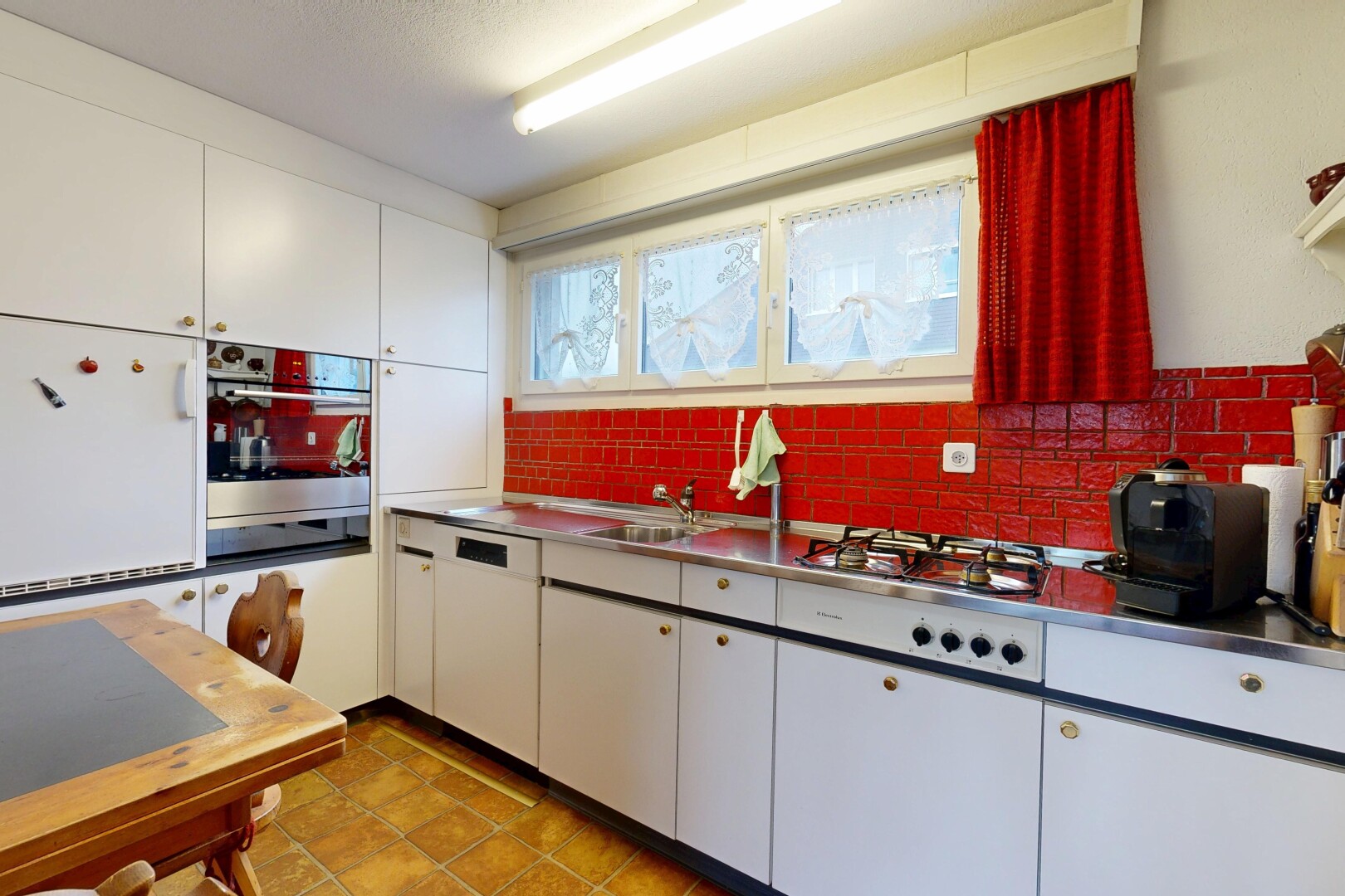 kitchen with stainless steel counters, white cabinets, white appliances, and tasteful backsplash
