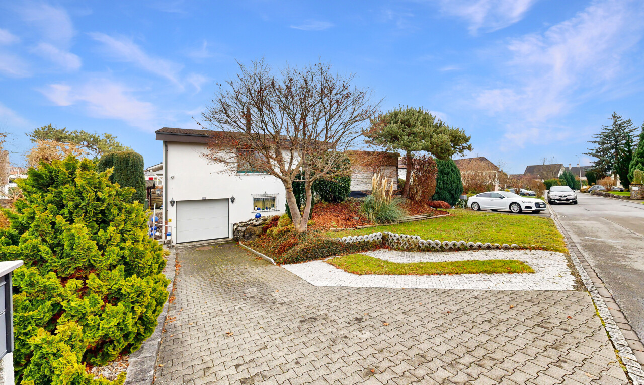view of home with a lawn, an attached garage, driveway, and stucco siding